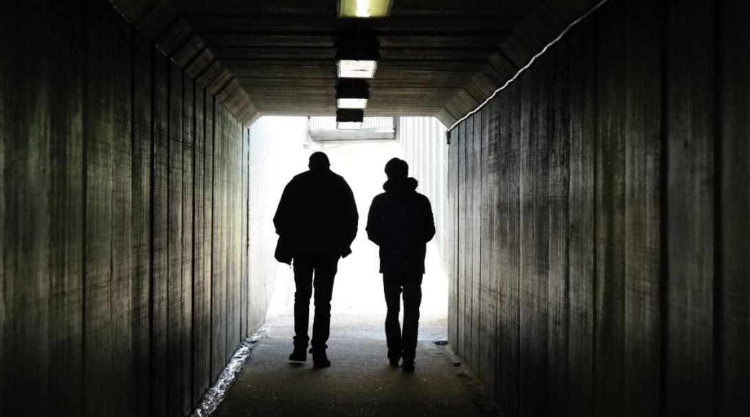 Two men walking throught a tunnel